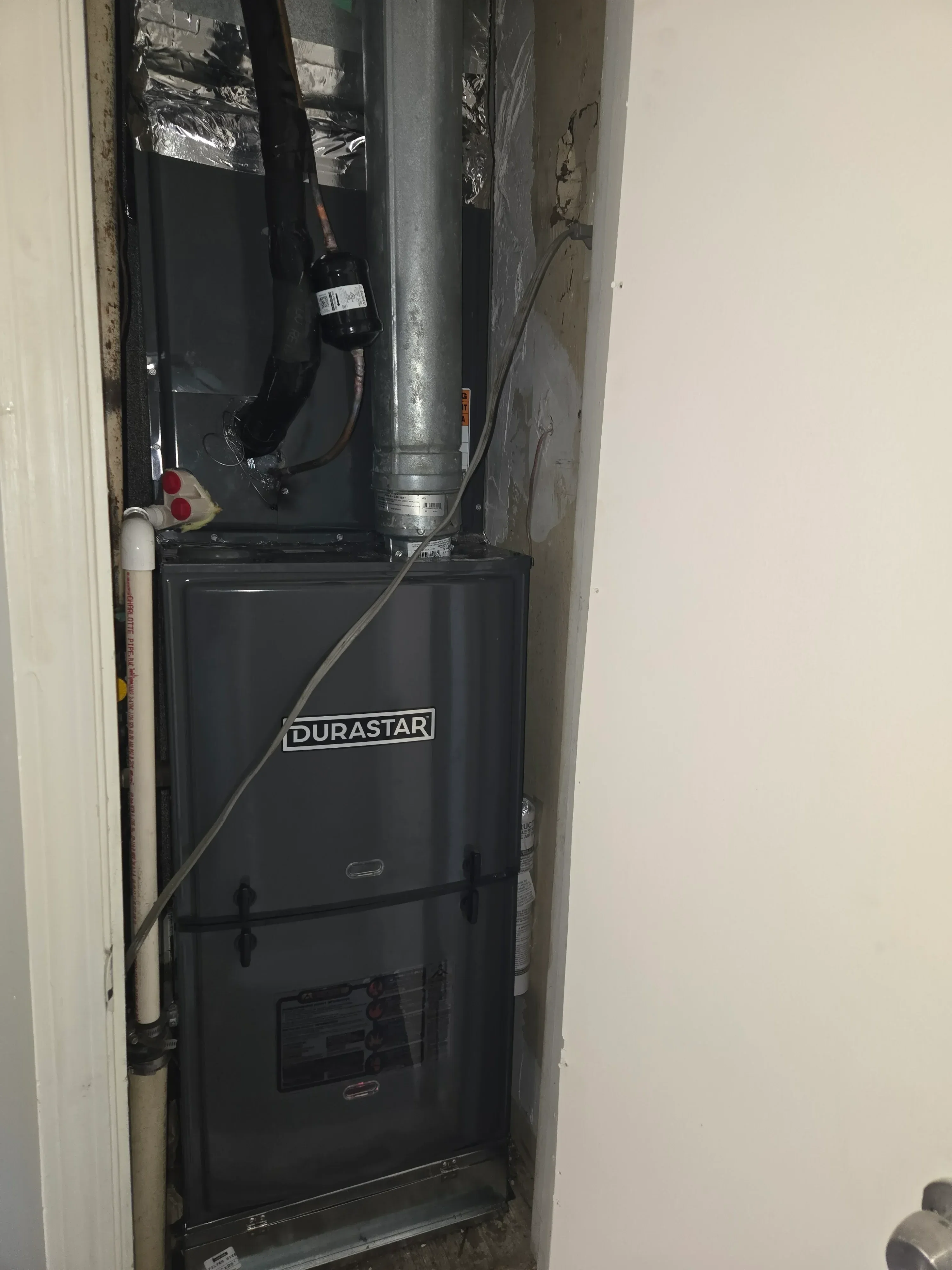 Ductless mini-split indoor unit installation with refrigerant lines and electrical wiring in soffit