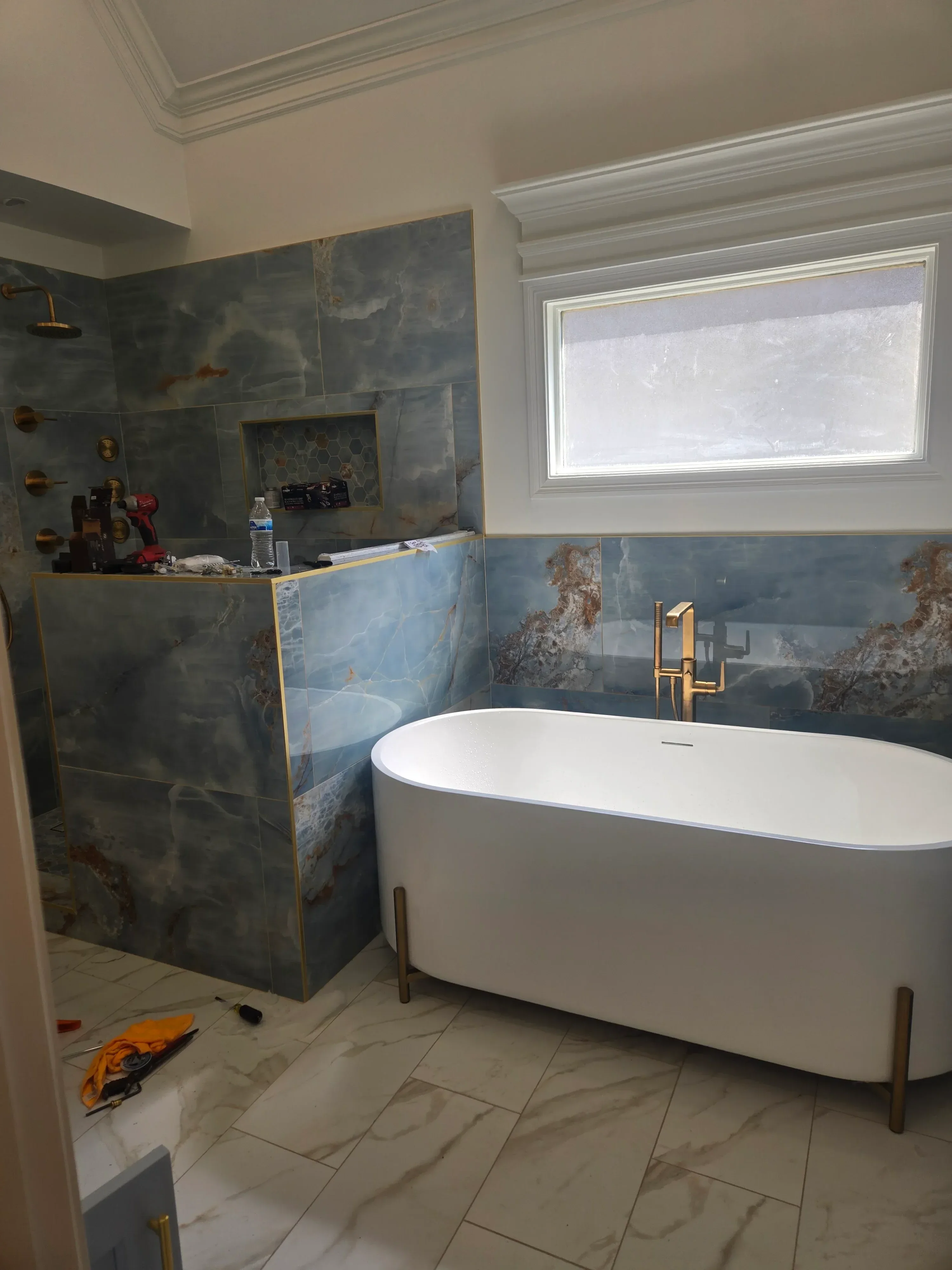 Bathroom renovation with slate tile flooring, HVAC ductwork, and modern fixtures during installation