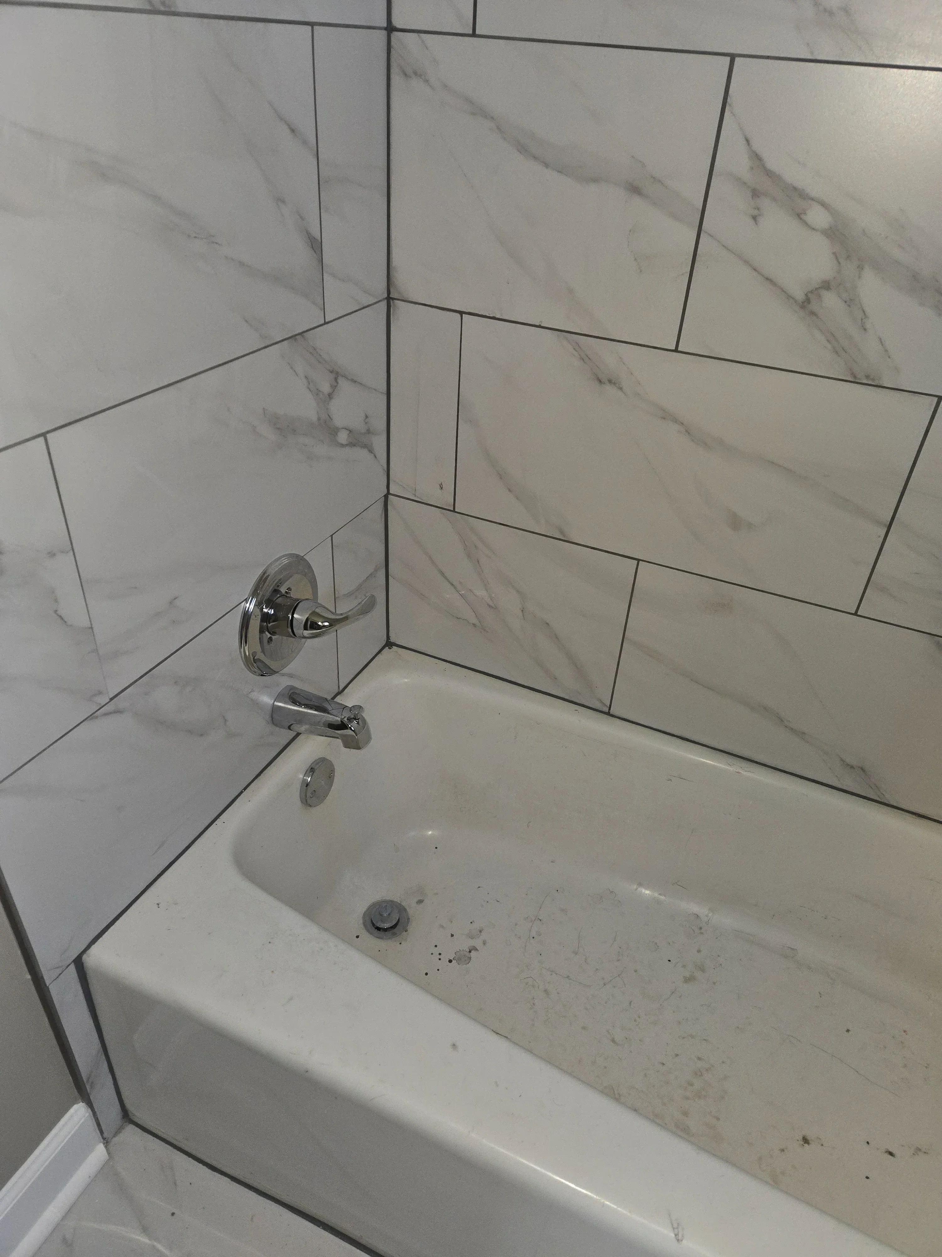 Herringbone marble-look tile walls and ceiling with chrome fixtures in bathroom