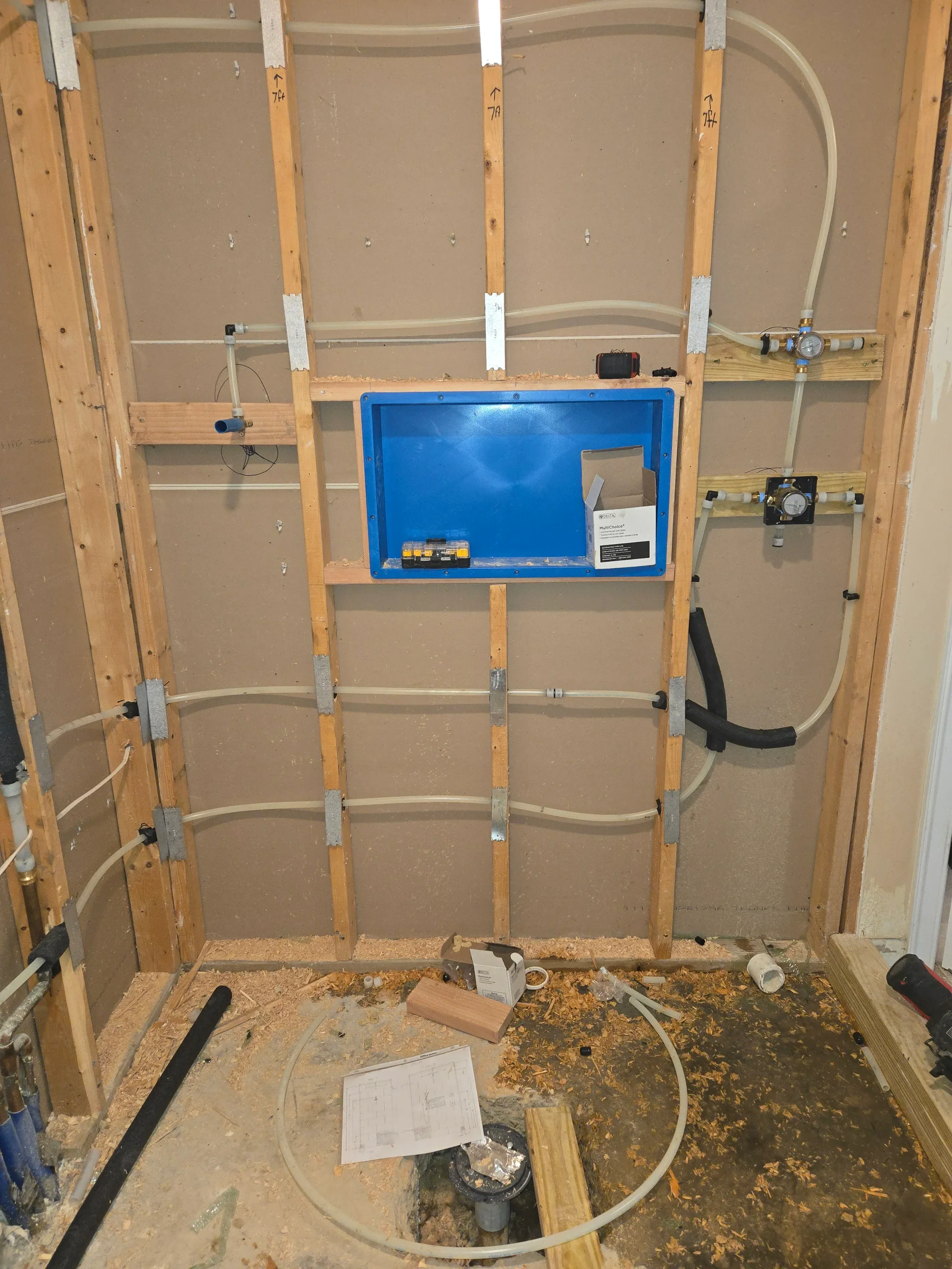 HVAC ductwork installation with rigid ducts, metal hangers, and control panel on wooden frame