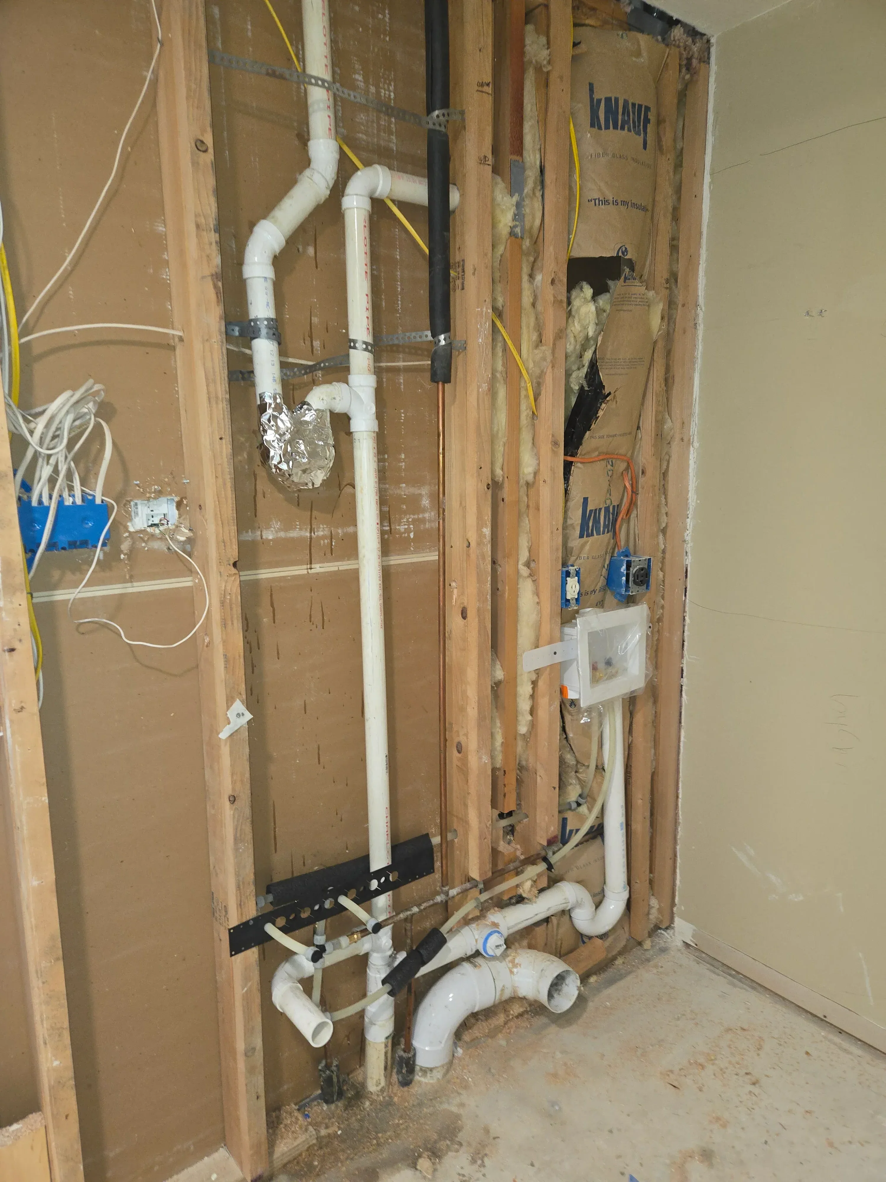 PEX tubing radiant heating system installed between wooden floor joists with manifold and controls