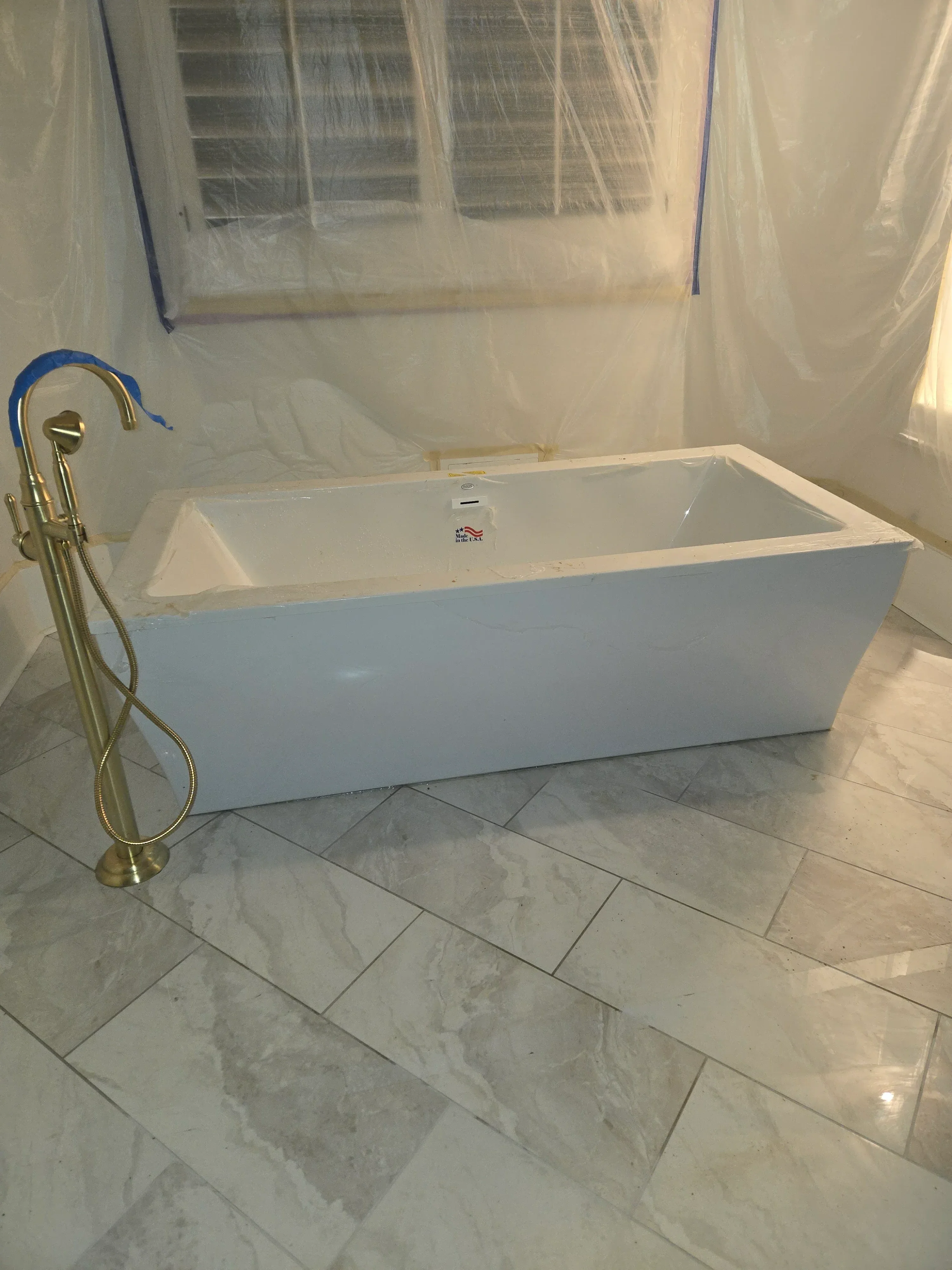 Brass exhaust fan with flexible ductwork installed in tiled bathroom during renovation